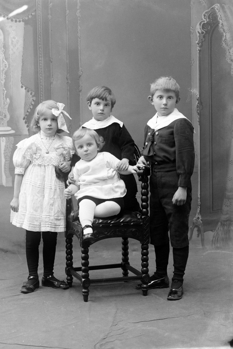Studioportrett av fire barn i helfigur.