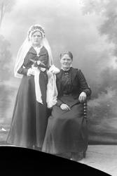 Studioportrett av en brud og en eldre kvinne.