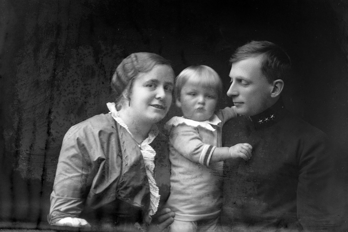 Studioportrett av en familie på tre i halvfigur.