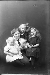 Studioportrett av Gerda Ursin-Holm med tre barn.
