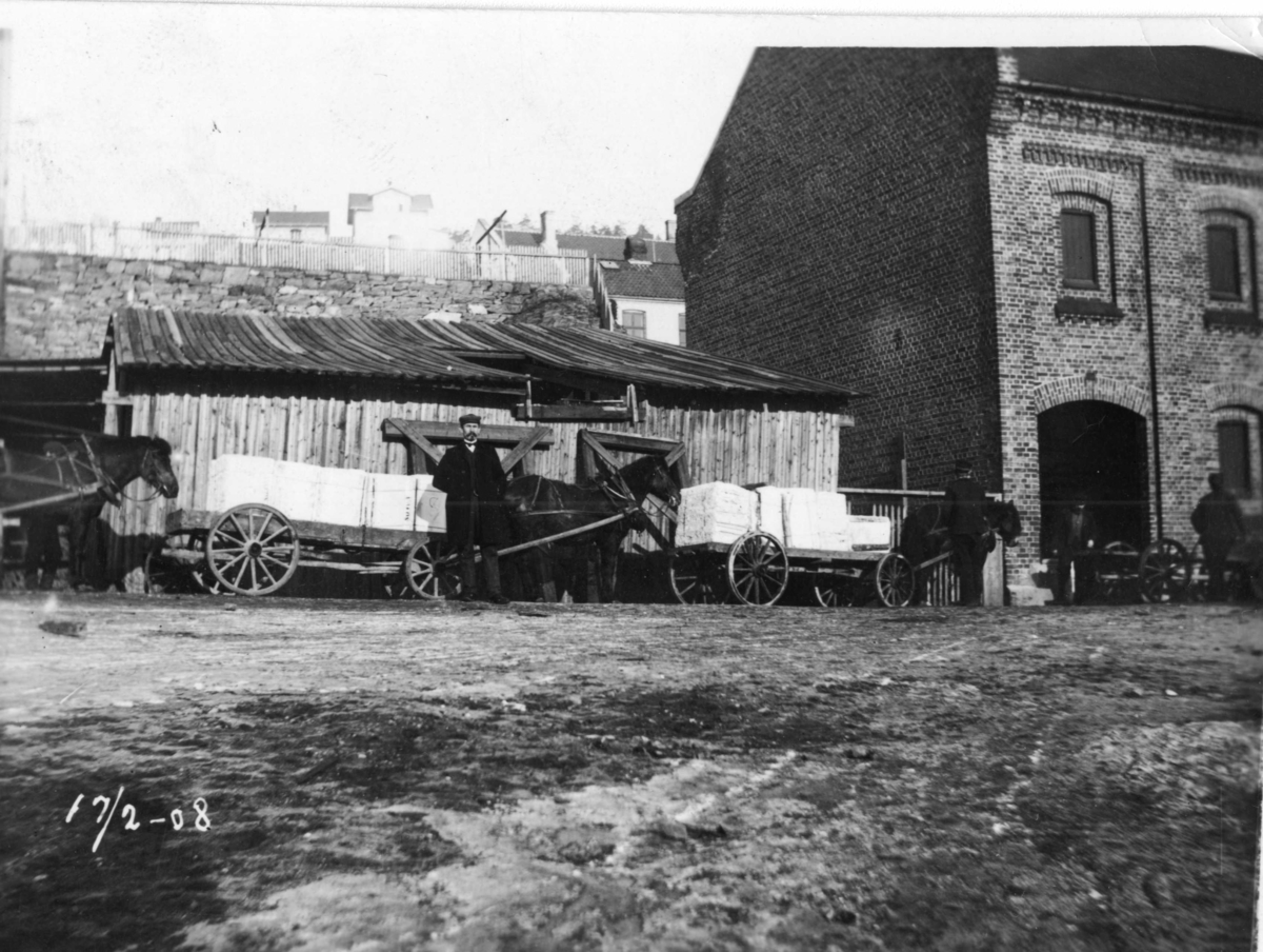 Hest og vogn frakter varer ved Lille Kirkebukta, Kragerø. Murbygget Excelsior fabrikker fremstilte sukkertøy og  ble senere Sol trikkotasje. 17.02.1908.