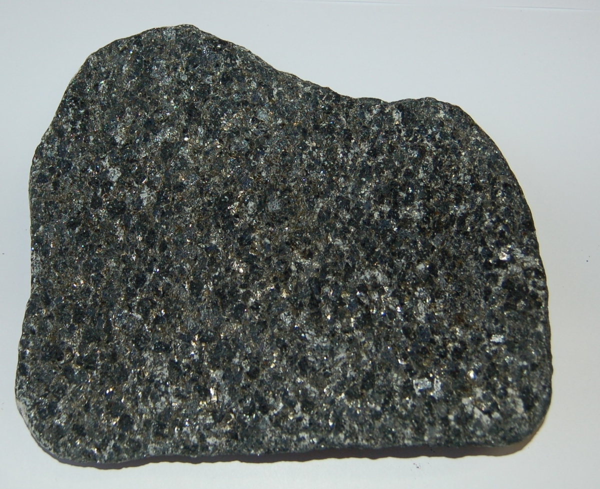 Form: Rektangulær steinhelle. Hellen er grå med svarte spetter på ene siden, mens den andre er helsvart