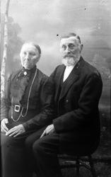 Studioportrett av en eldre mann og kvinne som sitter.
