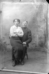 Studioportrett av en kvinne som sitter på en manns fang.