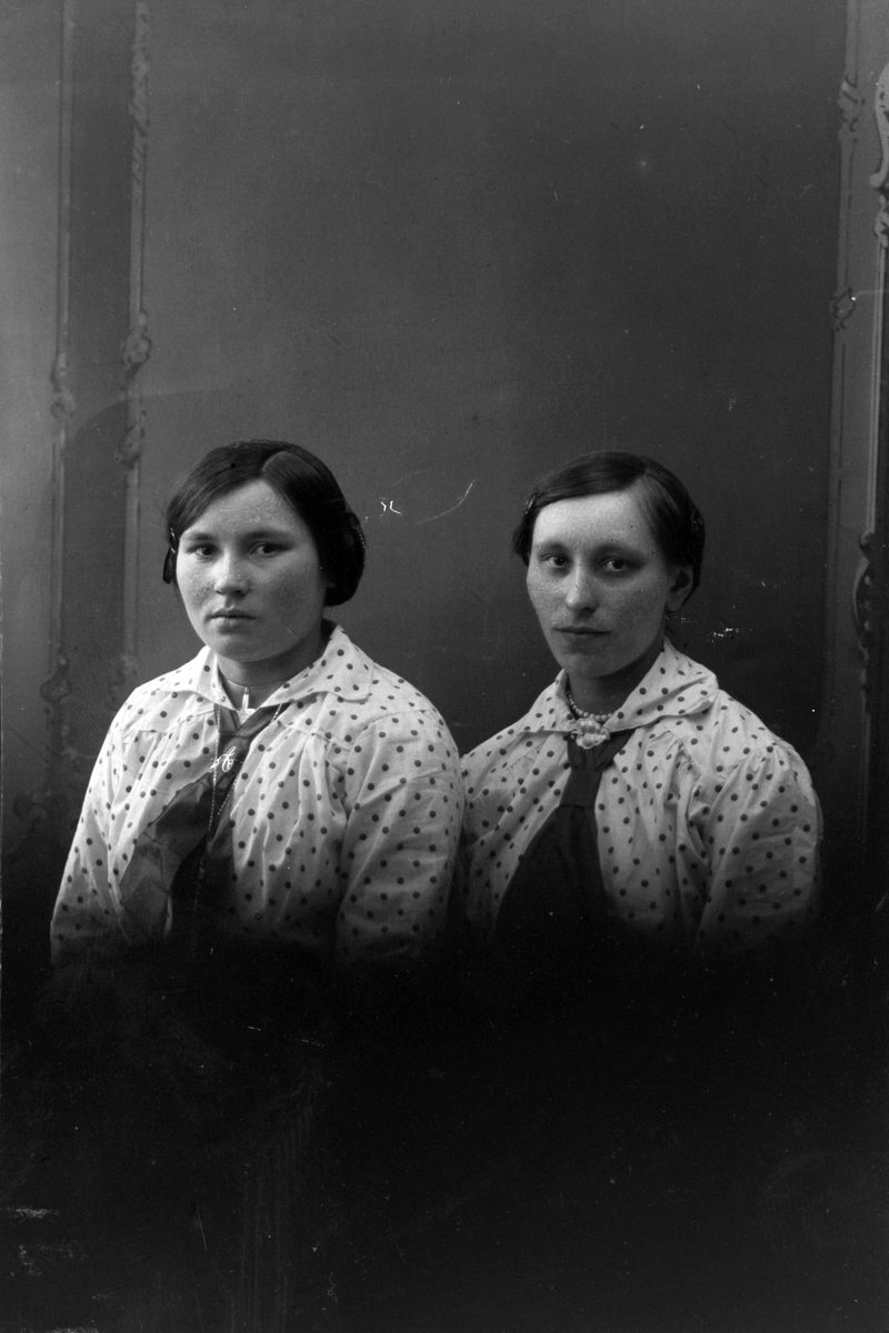 Studioportrett av to kvinner i prikkete skjorter med slips.