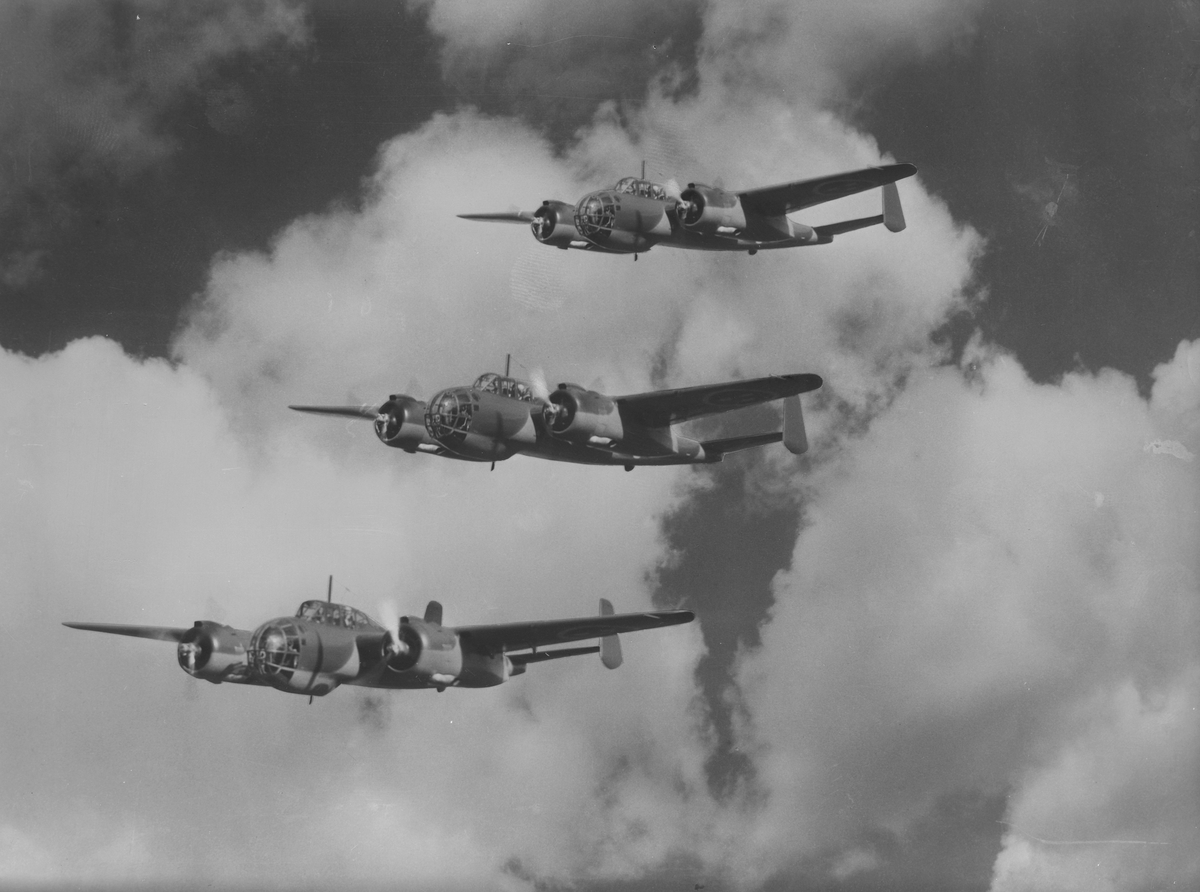 Tre flygplan B 18A i formationsflygning i luften.