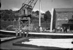 Lasteskip med bjelker fotografert, "Felleskjøpet" i bakgrunn