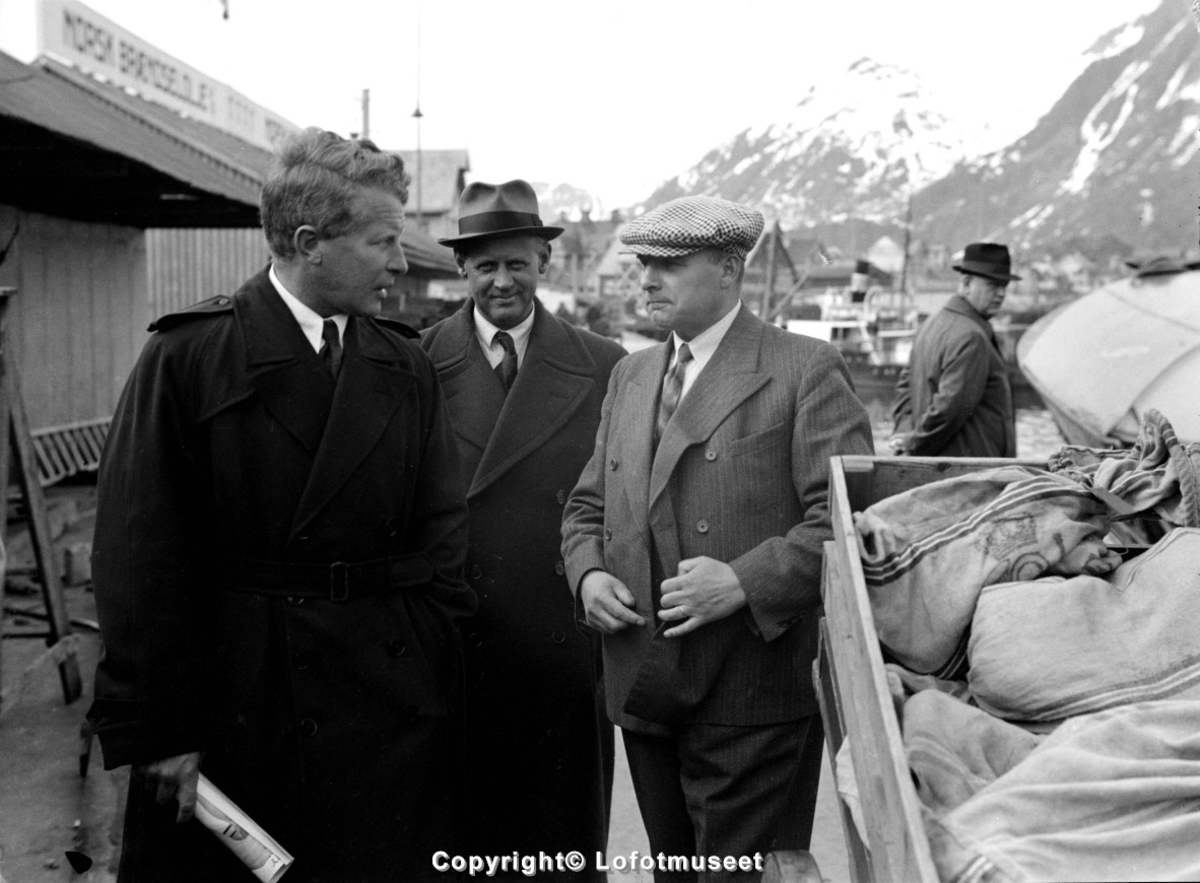 Svolvær, ca. 1950. Her ser vi tre menn i prat på dampskipskaia. Mannen i lys rutet sixpence er sannsynligvis flyveren Balshen.