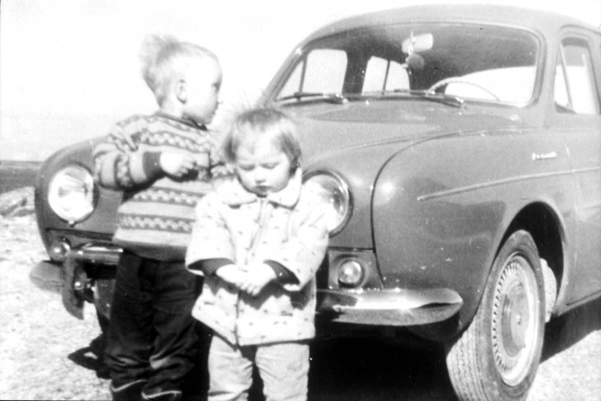 Gruppebilde. 2 personer, barn. Utendørs ved et kjøretøy - personbil,Renault Dauphine 1956-67.