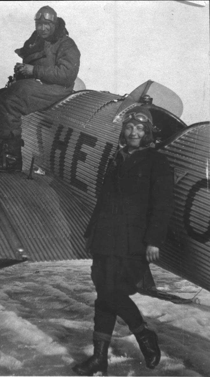 Ett Junkers Junior fly.Det er to personer ved siden av flyet.En mann og en kvinne. 