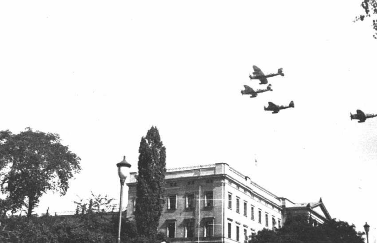 Fire fly på himmelen. Litt av en bygning på bakken.
Flytype P-47 Thunderbolt