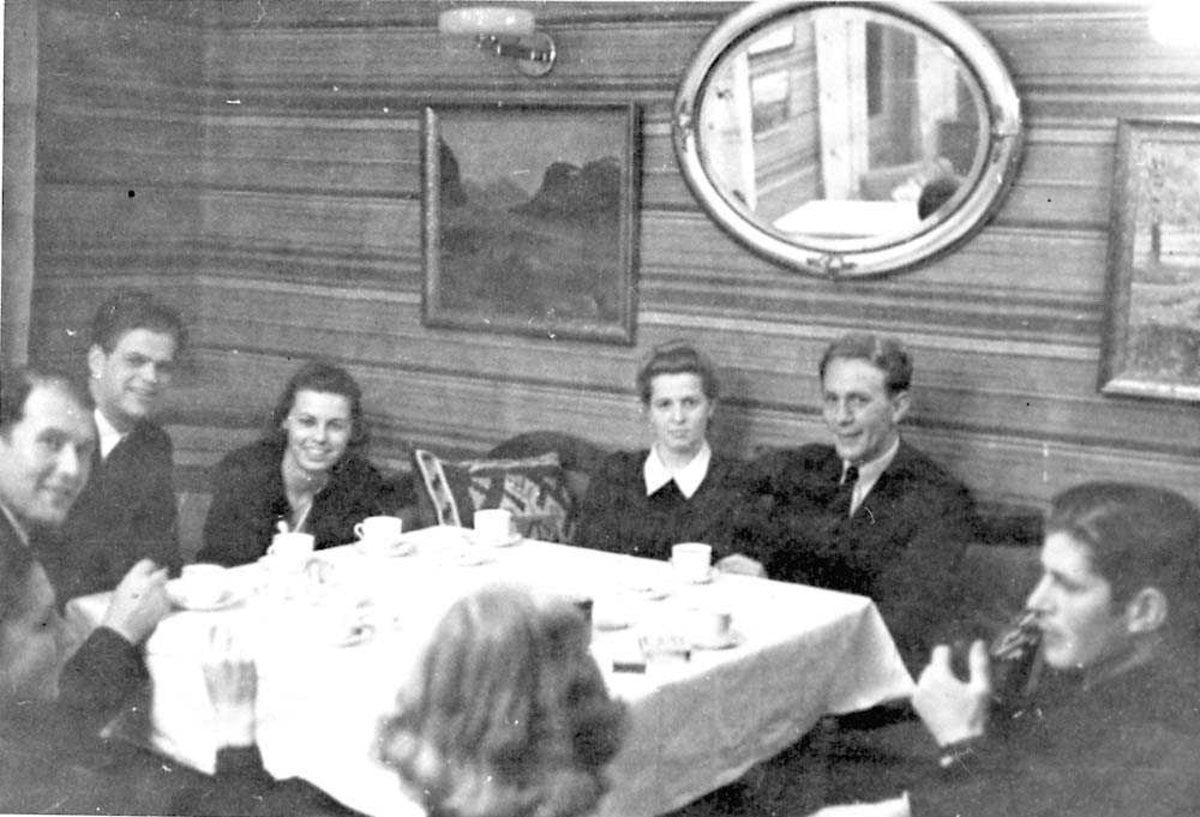 Gruppefoto av sju personer som sitter rundt et bord.