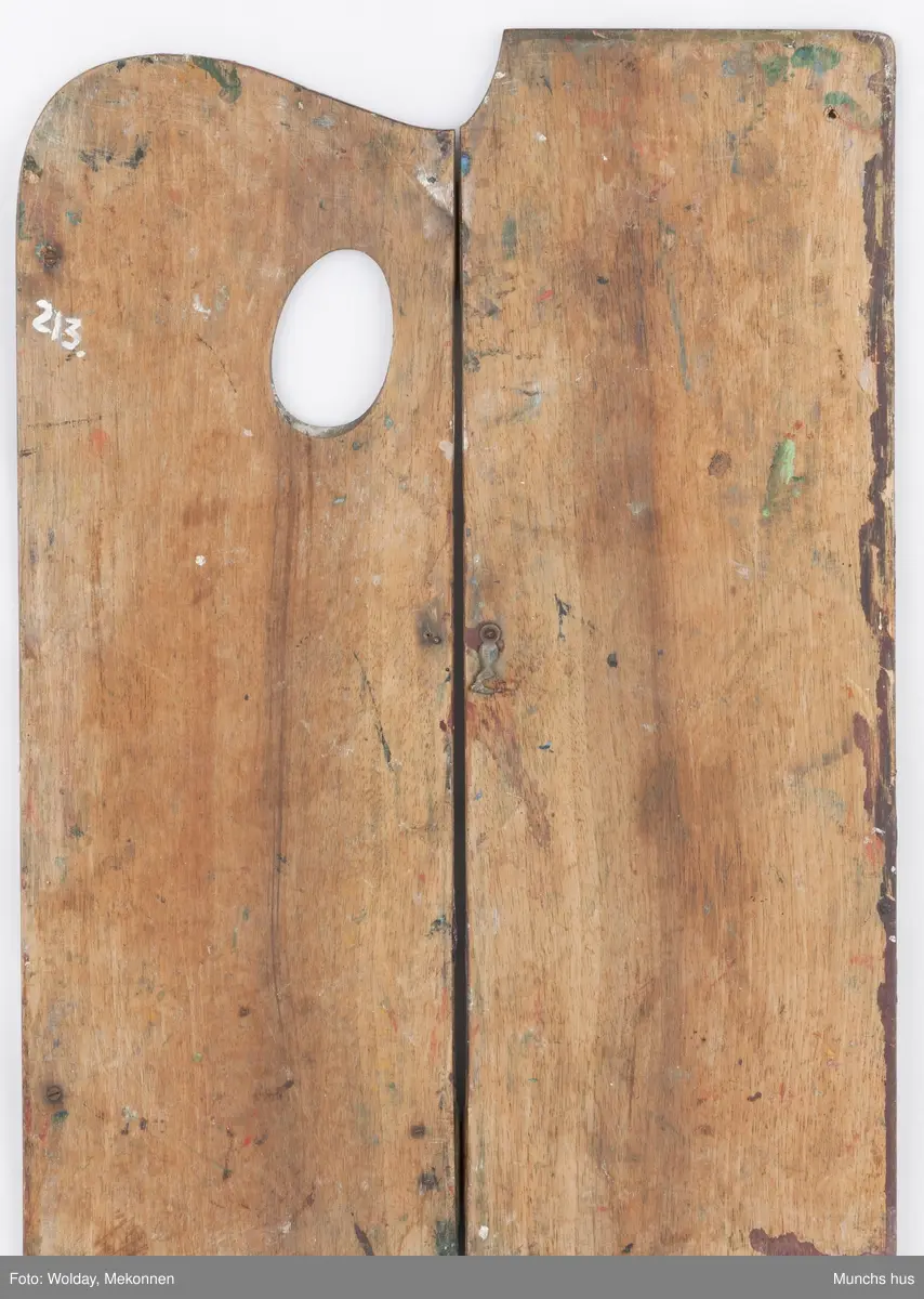 Malepalett i tre. Paletten er brukt og har mange spor av maling i ulike farger.