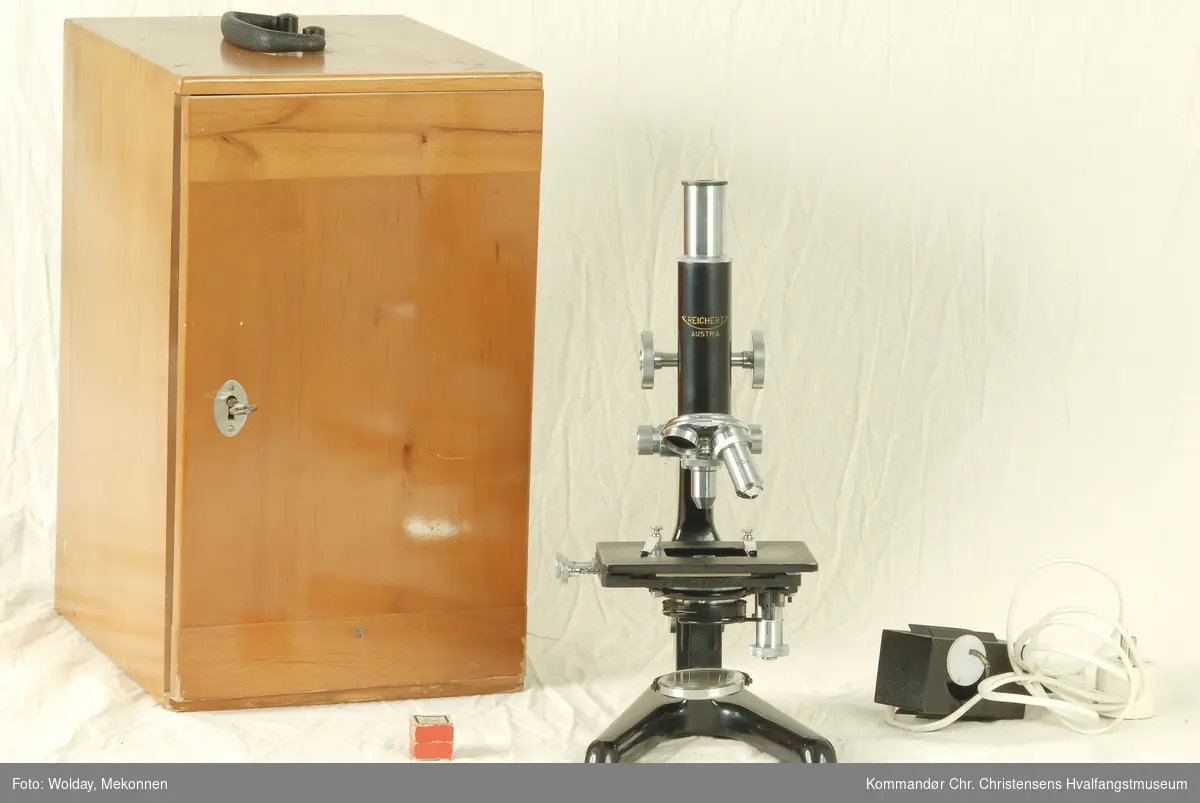 Form: Mikroskop med okularer. Treskap til oppbevaring av 
mikroskopet.