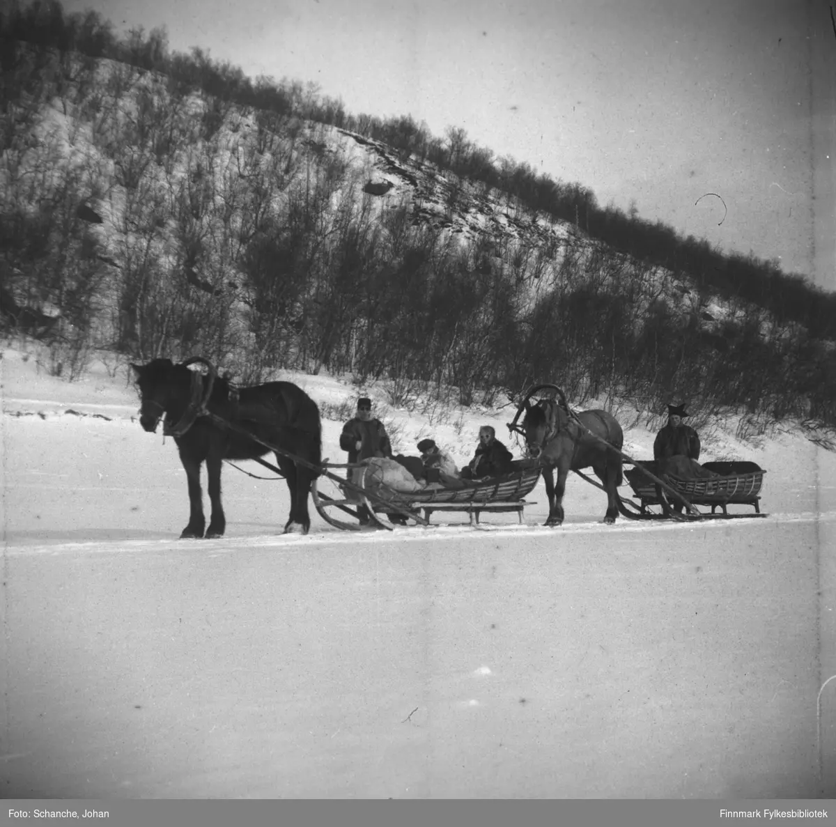 To mennn og to kvinner kjører to hester med sleder på isen over Tanaelva påsken -48. Sledene ble kalt styrslede og var spesielt laget for turkjøring og har seletøy med en bue/bøyle over ryggen på hesten. Hesten hadde også en bjelle som stod på hesteryggen, kalt Sedolk, muligens av finsk opprinnelse. Den ene av mennene er kledd i sameklær / pesk og står ved siden av sleden. På den andre sleden sitter to kvinner.  Landskapet er dekt av snø.