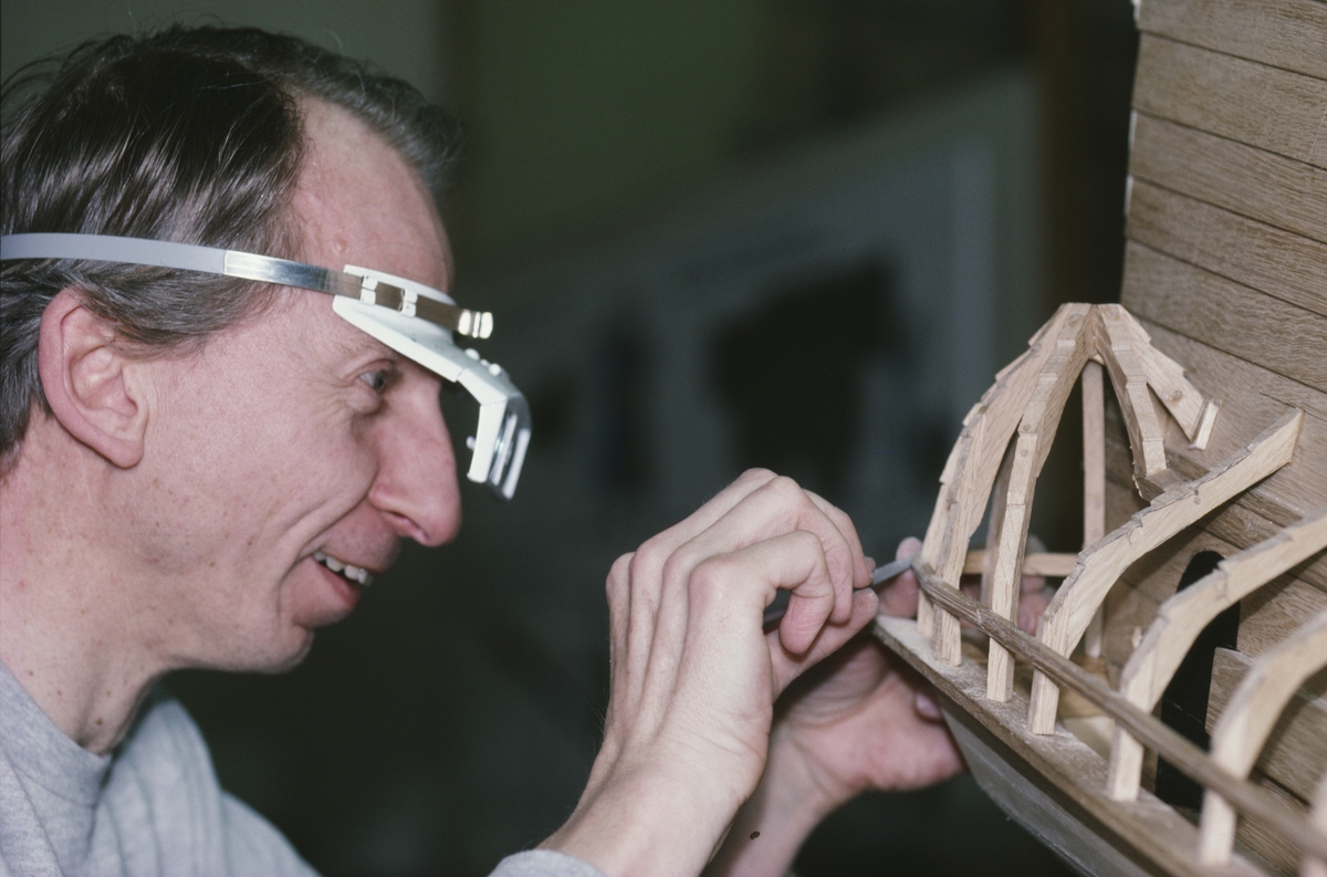 Modellkonservator Göran Forss justerar aktergalleriet på modellen av Vasa i skala 1:10.
