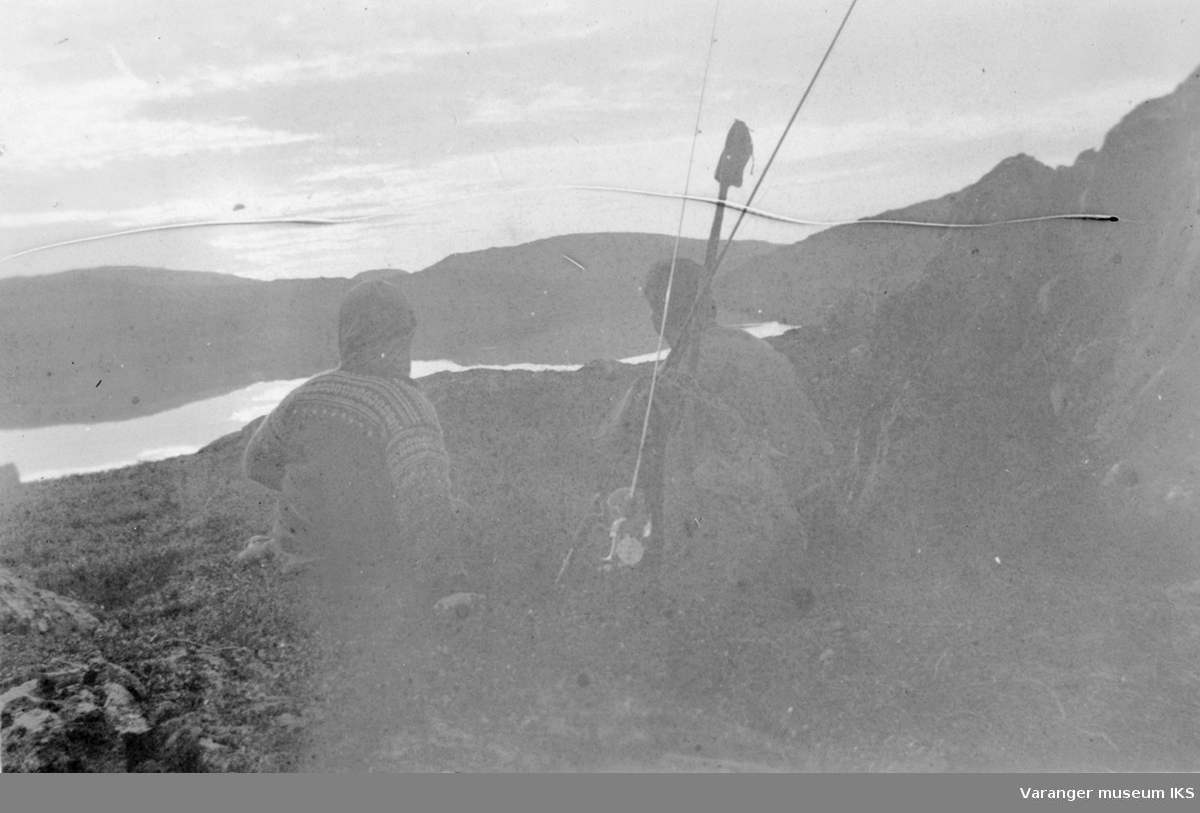 Tre personer med oppakning vandrer i arktisk landskap. Varangerhalvøya, høsten 1944.