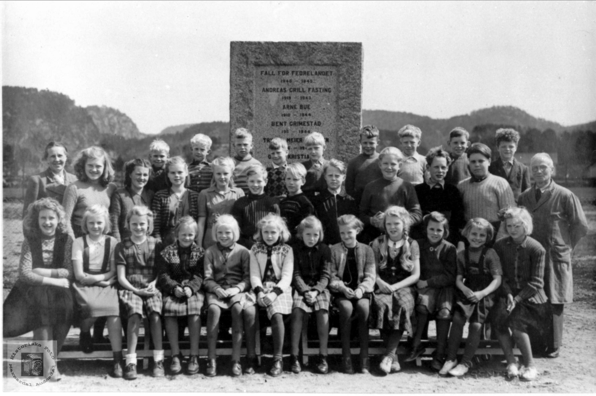 Skoleklasse på Øyslebø fremfor minnestøtten