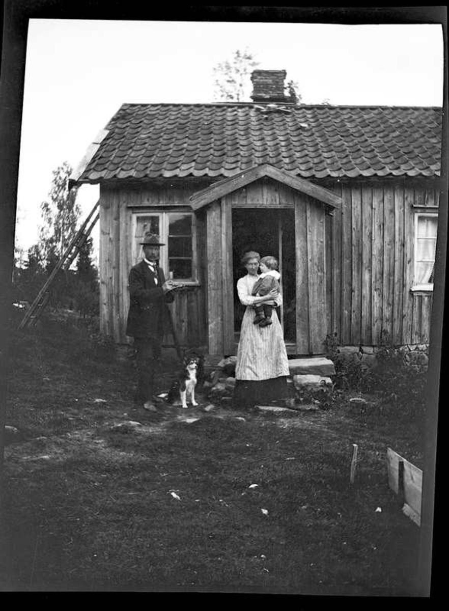 Okänd, Olga, född Olsson, Forshälla 1891-05-12  Sven, Hjärtum 1915-05-14, som står framför boningshuset.