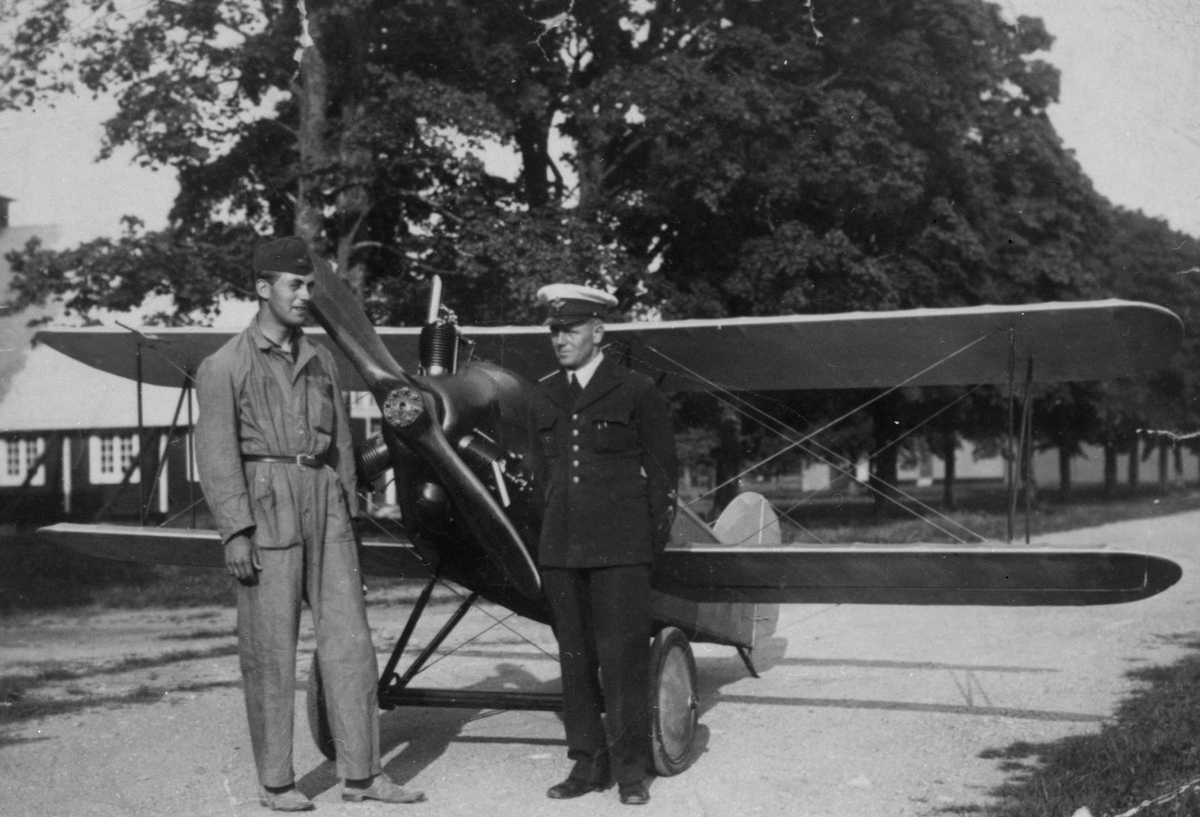 Porträtt. Två militärer framför det civila flygplanet Holmberg Racer på Malmen. Flygplanet var ett hemmabygge av tyghantverkare George Holmberg, till höger.