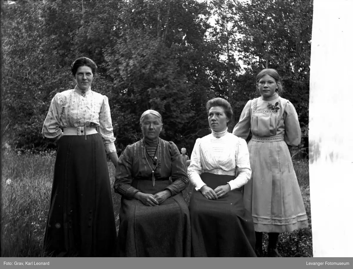 Gruppebilde, tre kvinner og en jente i hage.(se gutten bak)