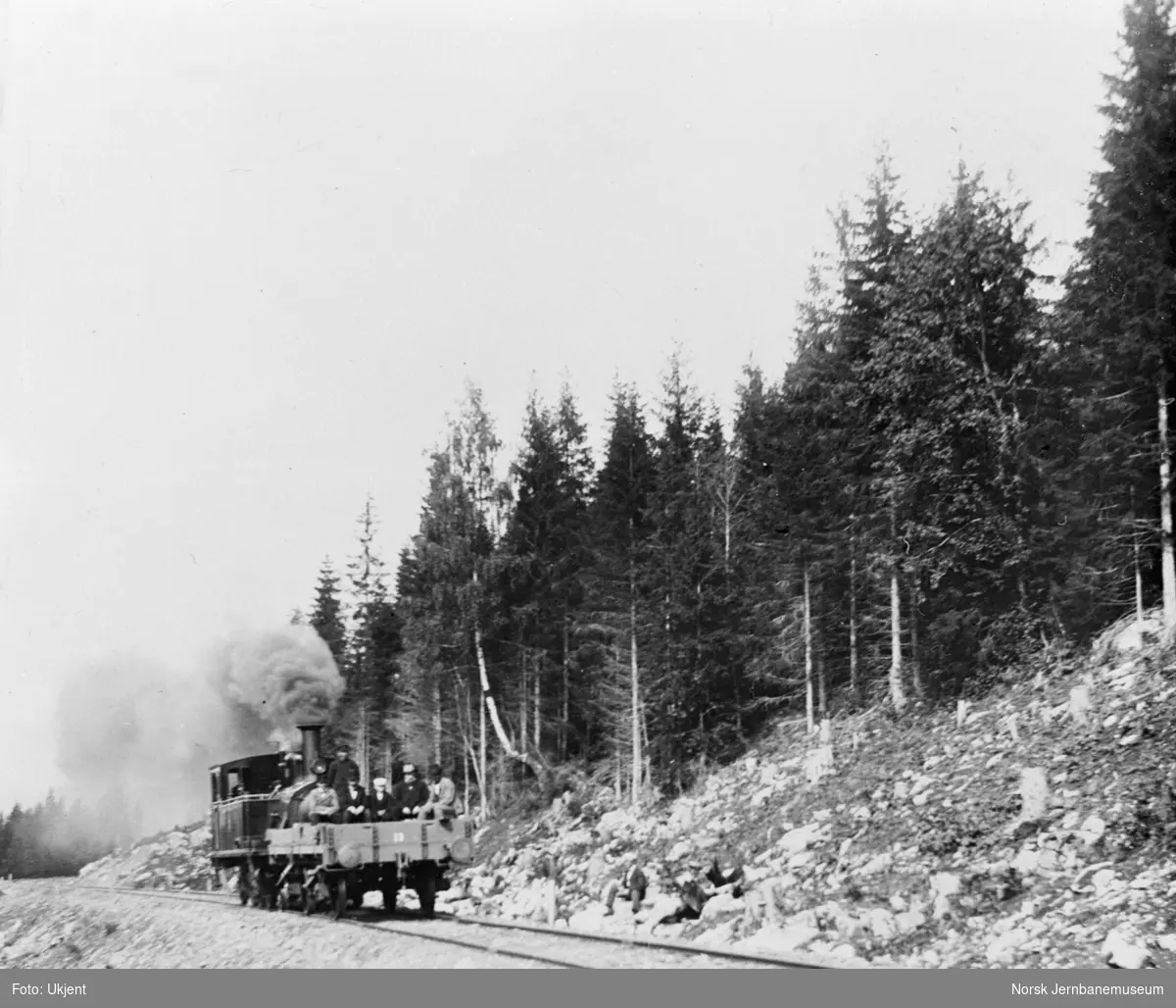 Damplokomotiv med grusvogn med folk under anlegget - befaring, foto mellom Fall og Skrukli
