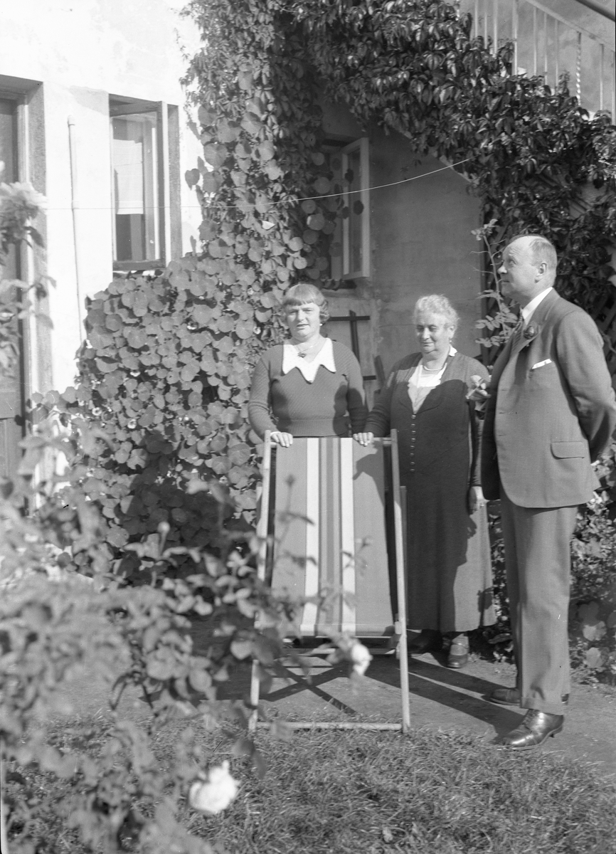 To kvinner og en mann i hagen hos Lyng Olsen i Parken. Kragerø