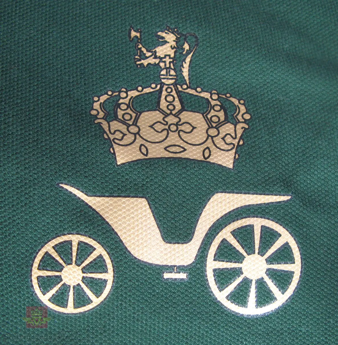 Pikèskjorte, størrelse S, grønn bunnfarge, knepping i halsen, gullfarget kongeveglogo med motiv som inneholder vogn og krone med løve.