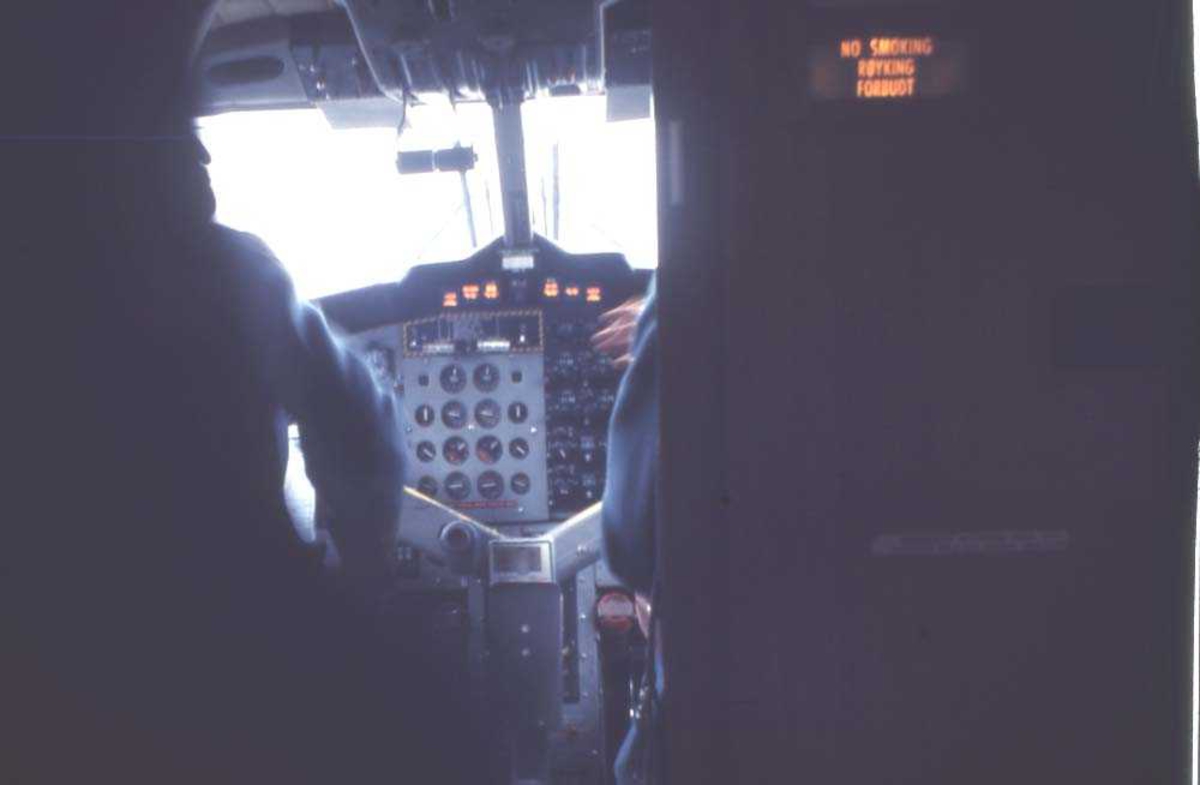 Lufthavn/flyplass. Florø. Parti av instrumentpanelet til et fly, DHC-6-300 Twin Otter fra Widerøe. 2 piloter/flygere skimtes gjennom cockpitdøra.