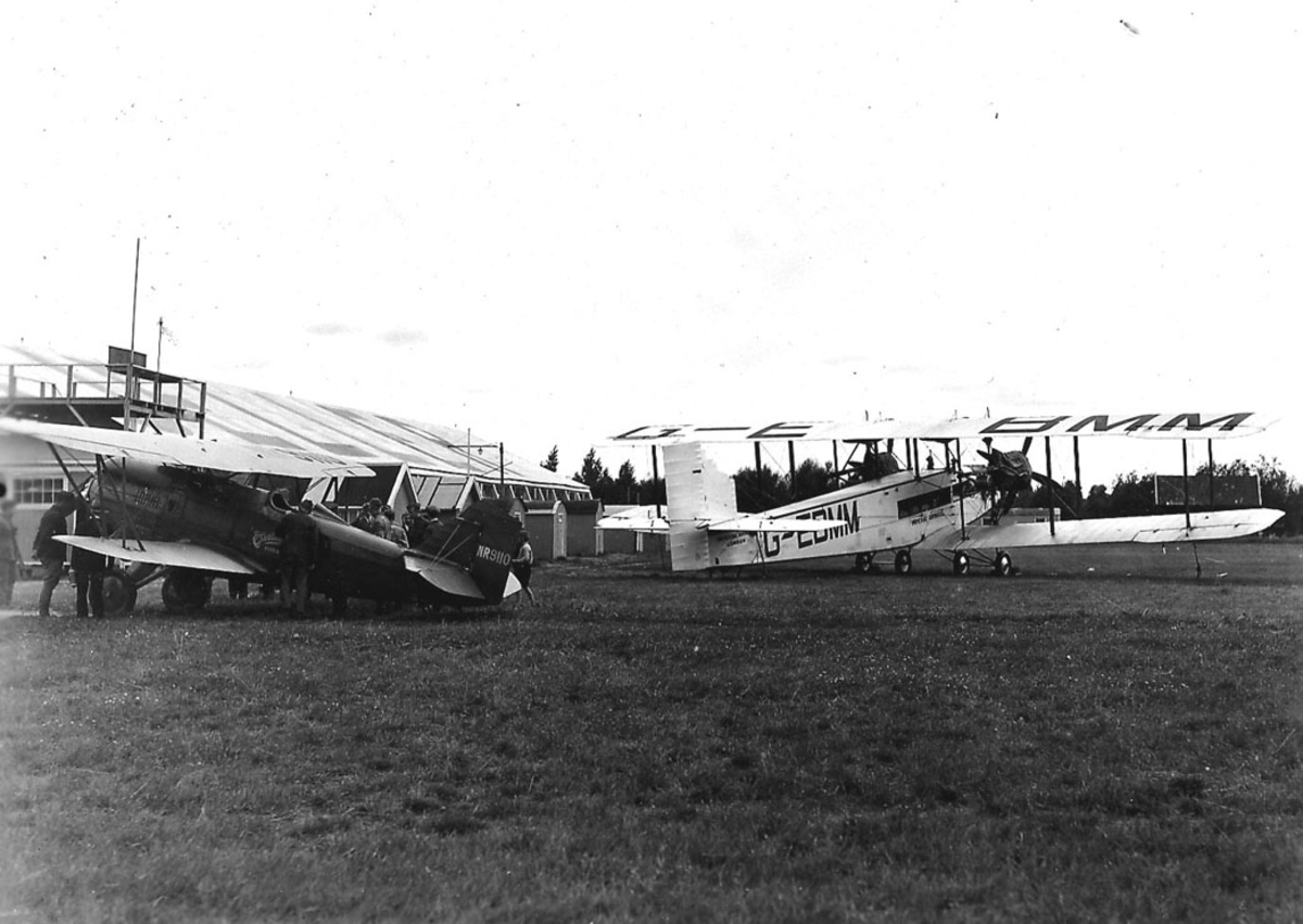 Åpen plass,Kjeller  lufthavn, to fly på bakken, Curtiss Hawk,  reg nr  NR 9110. Handley Page "Clive"fra  Imperial Airways (G-EBMM). 1 bygning i bakgrunnen.