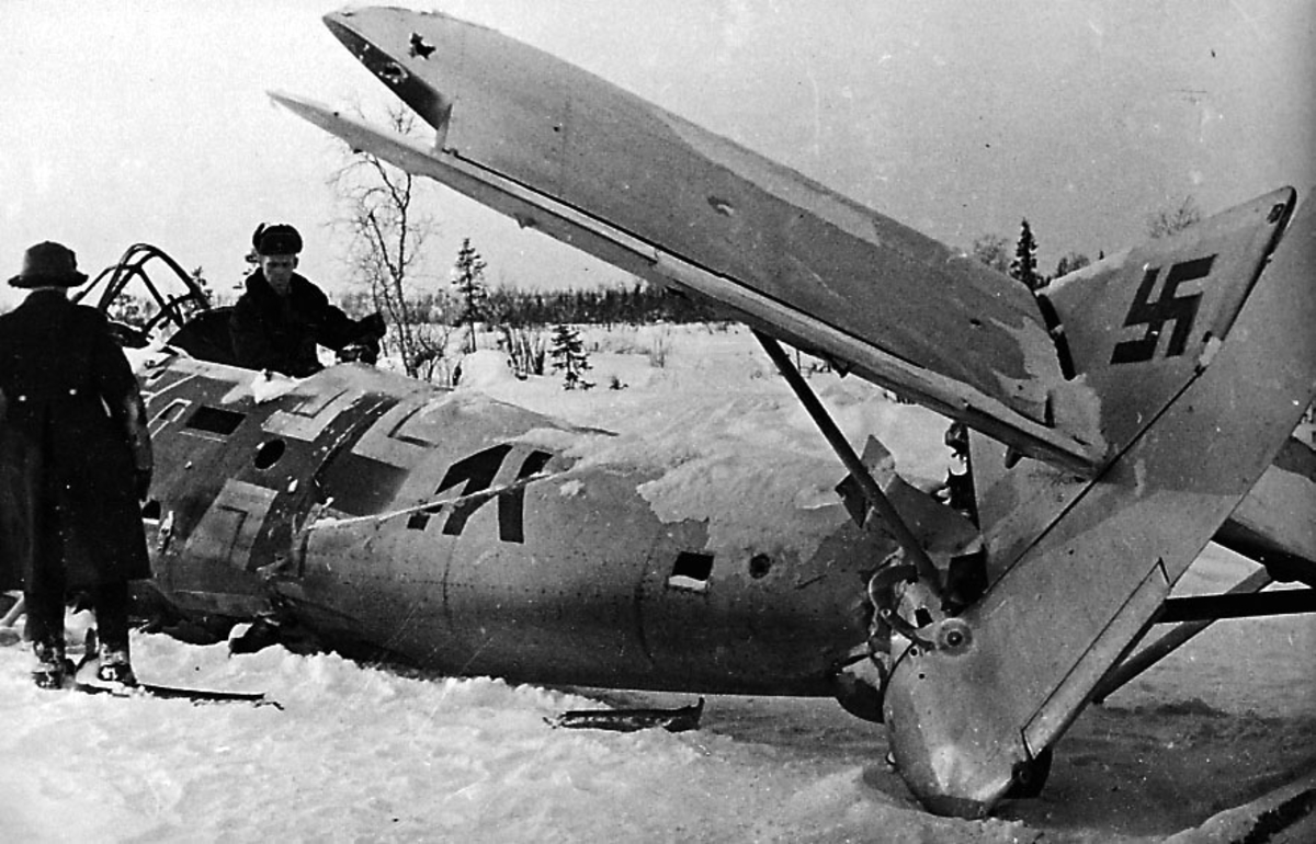 Ett ødelagt fly på bakken Dornier DO-18. 2 personer ved flyet. Flyhavari etter nedskyting. Hakekors malt på halepartiet. Snø på bakken.
