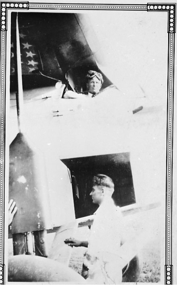 "Portrett", to personer, en av dem i cockpiten på et fly, en av dem står ved siden av.