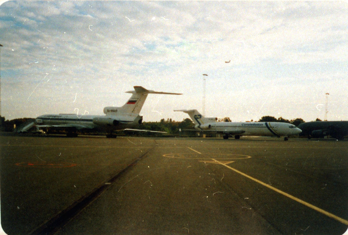 Lufthavn, 2 fly på bakken, foran Tupolev 154, RA-B5605. Bak Boeing 727. Litt av rullebanen i forgrunnen.