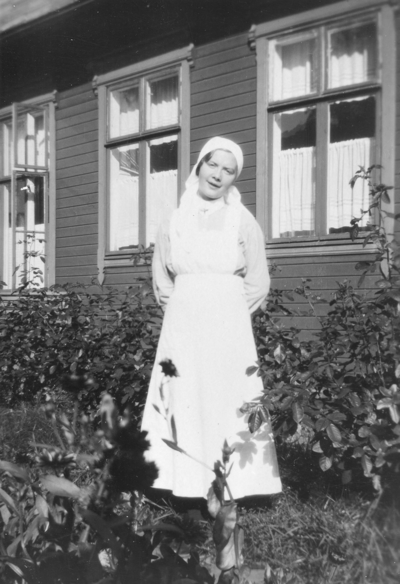 Sykepleier i hagen utenfor gamle Harstad sykehus.