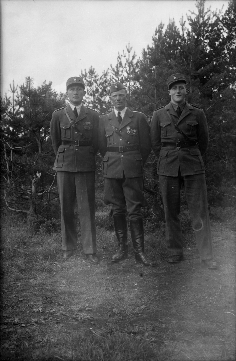 Tre unge menn i uniform fotografert utendørs
