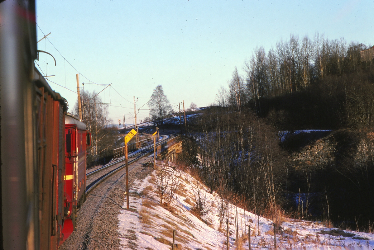 Tog 301, dagtoget Oslo - Trondheim over Røros, kjører inn på Børke bru mellom Leirsund og Frogner. Innkjørhovedsignalet på Frogner stasjon kan sees på bilde. Lokomotiv type El 11.