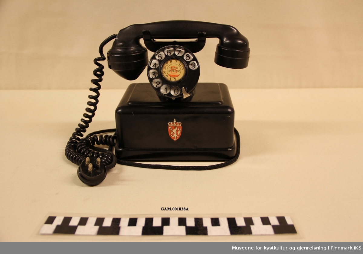 Telefonen er dekoret med Norges riksvåpen. I midten av tallskive det er trykket teksten "vent på summetonen."