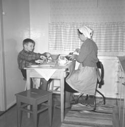 Aase og sønnen Arne Jacobsen ved middagsbordet på kjøkkenet 