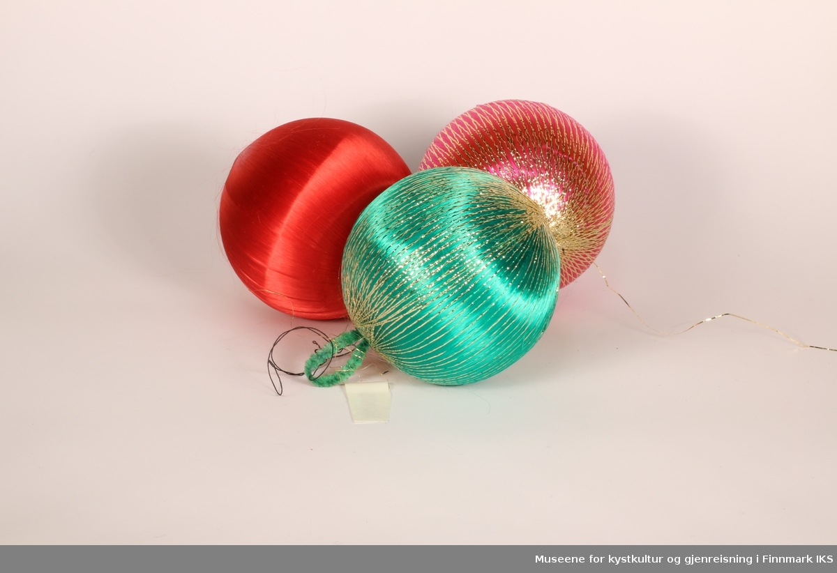 3 julekuler dekket av silketråd. A er hel i hel rød, B er grønn med gulltråd, C er rosa med gulltråd.
