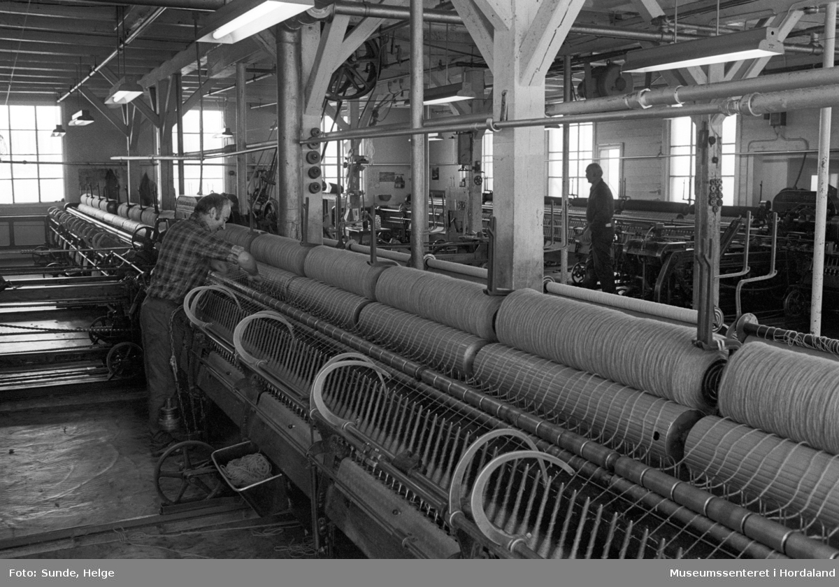 Arbeidsliv ved Salhus Tricotagefabrik i Salhus, Bergen i 1976. Arbeidarar ved selfaktor i 1900-bygget på Salhus Tricotagefabrik.