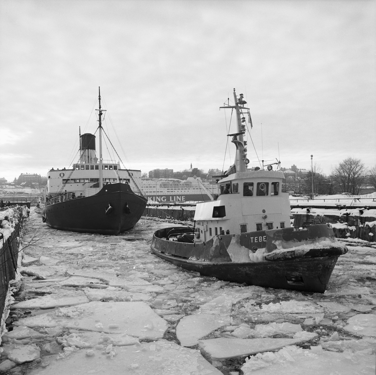 Isbrytaren Sankt Erik bogseras till dockan på Beckholmen under vintern 1987.