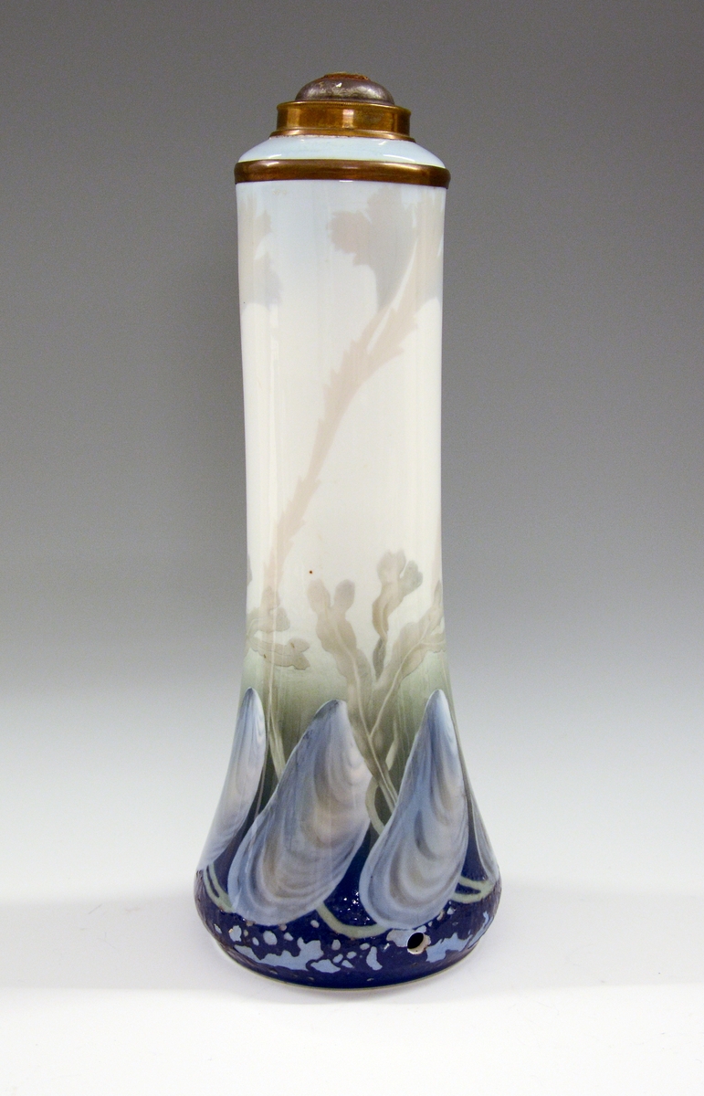 Vase av porselen, slank, glatt med lang hals. Underglasurdekor.
Modell 1500.
Dekornr. 46 Skjell og tang tegnet av Thorolf Holmboe.
Gjort om til lampefot.