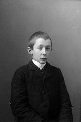 Studioportrett av gutt i halvfigur.