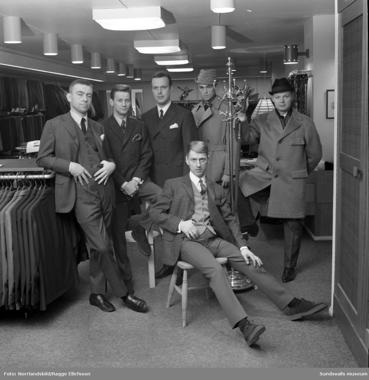 Manliga mannekänger visar kläder inne på Henrix herrekipering för annonsfotografering.