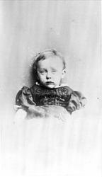 Vignettert portrett i halvfigur av liten jente.