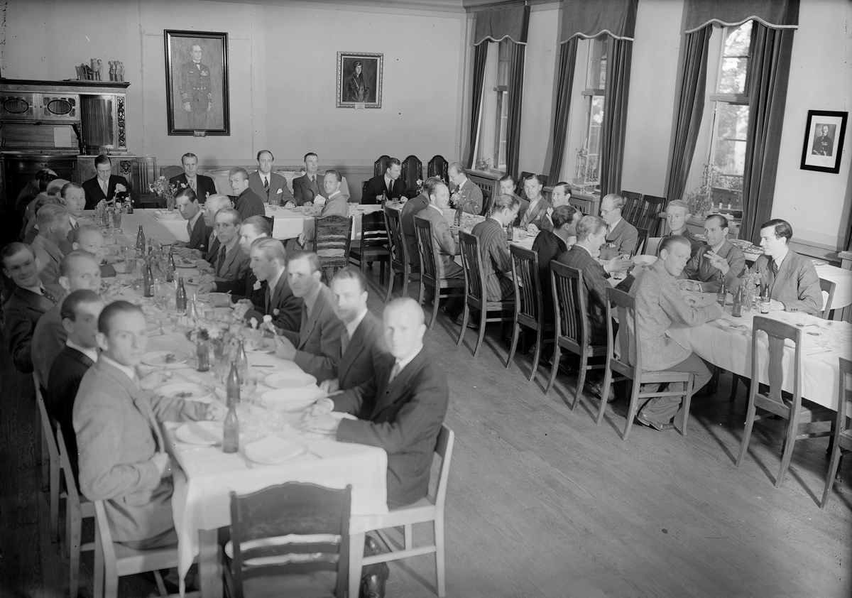 Sista middagen på gamla officersmässen på F 3 Östgöta flygflottilj, 1943. Grupporträtt av män sittandes till bords.