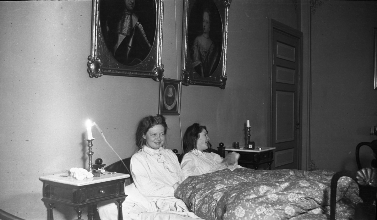 Fotoarkivet etter Gunnar Knudsen. Borgestad gård, to jenter i en seng fotografert. Til venstre sees Gunnar Knudsens datter Margit (Maggit)