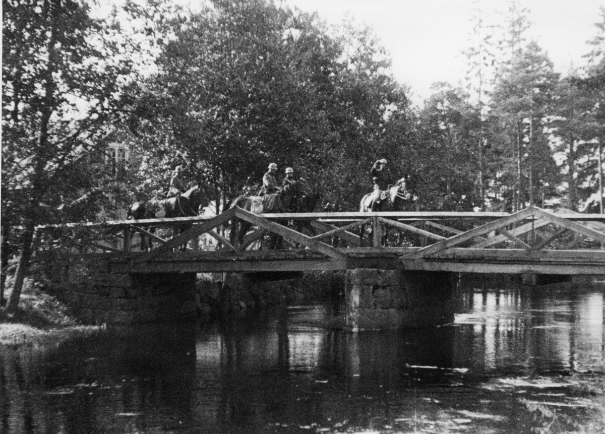 Hästanspännt förband passerar bro.