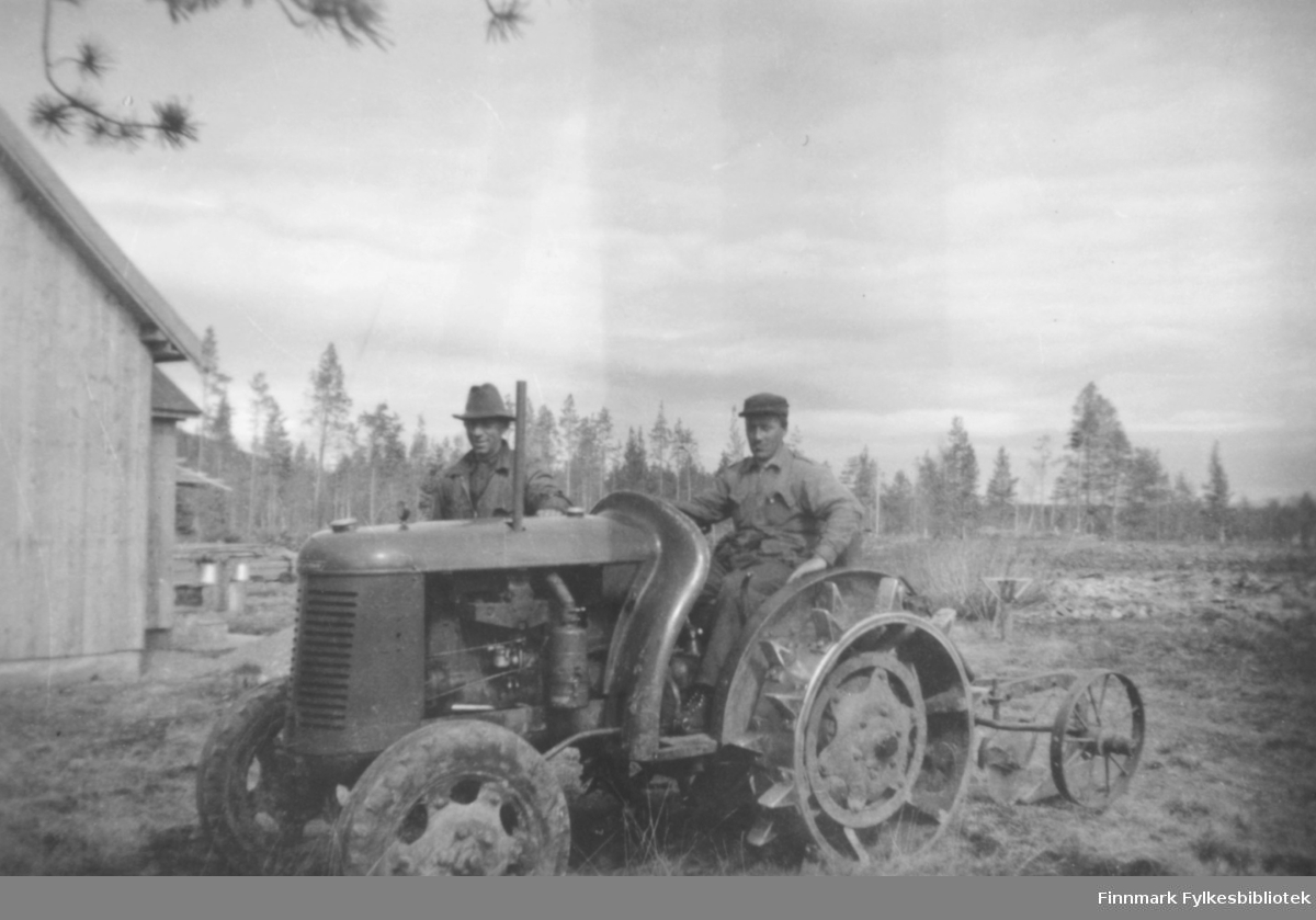 Ukjent mann på en David Brown-traktor. En plog er festet til traktoren. Kristian Wisløff stående bak traktoren iført hatt. Vi ser udyrka mark rundt, og furutrær i bakgrunnen. Til venstre ser vi en bygning og noen spann?
