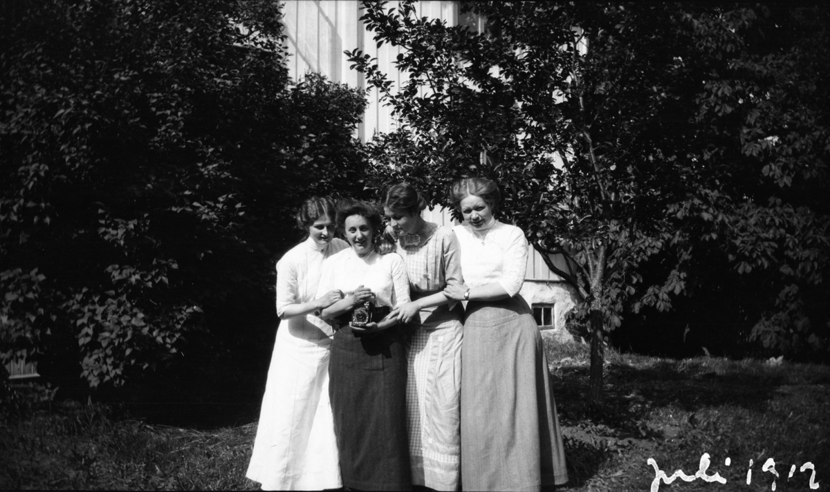Portrett av fire kvinner med fotoapparat, tatt juli 1912. Ytterst til høyre Gunnar Knudsens datter Margit, (Maggit).

Fotoarkivet etter Gunnar Knudsen.